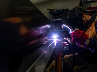 Welder is welding Tungsten Inert Gas welding, TIG weld for making new stainless flexible hose in...