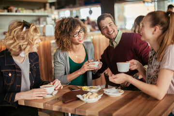 Group of young and diverse friends having coffee together in a cafe or bar