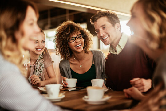 Group of young and diverse friends having coffee together in a cafe or bar