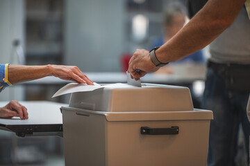 Ein Wähler wirft seinen Stimmzettel in die Wahlurne. Symbolbild für Wahlen und...