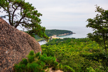 Views hiking beehive loop in Acadia National park. Greenery, rocky coastline, and lakes, and Sand Beach, seen from a top the mountain.