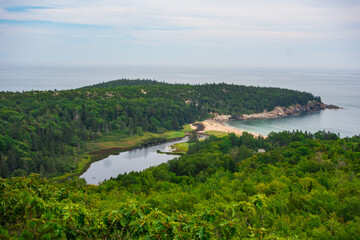 Views hiking beehive loop in Acadia National park. Greenery, rocky coastline, and lakes, and Sand Beach, seen from a top the mountain.