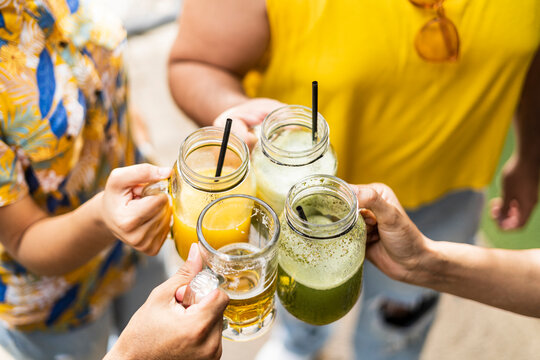image of a group of four unrecognizable friends from the lgbt community toasting with different drinks and proud to be free and able to express themselves. 