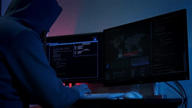 Unrecognizable hacker man typing on keyboard and engaging hacking into security systems