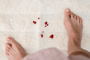 Drops blood stains from menstruation on white fluffy carpet. daily life stain concept. top view.