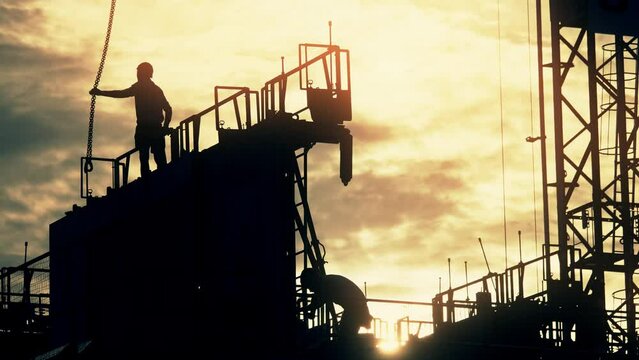 Silhouettes of unknown construction workers on modern residential building construction site