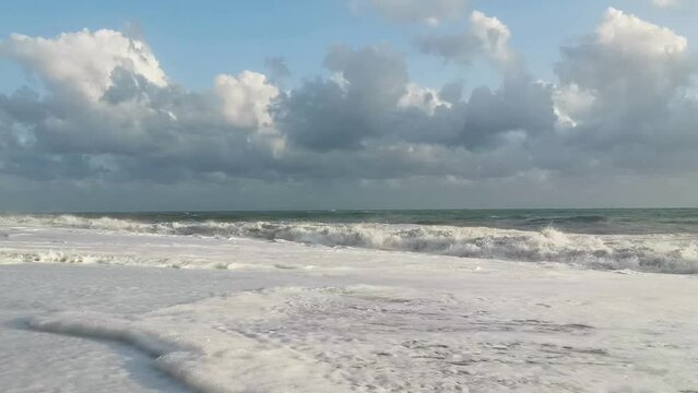 Lunga Spiaggia solitaria in un giorno di fine estate con il mare agitato e le nuvole