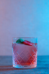 pink cocktail with strawberries in neon light