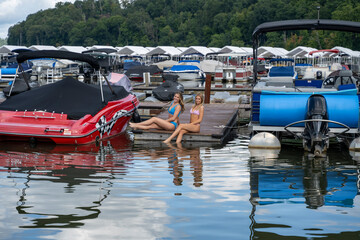 Fototapeta na wymiar Two pretty young girls at a boat marina