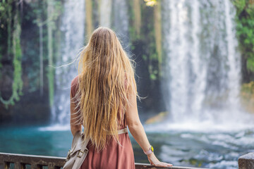 Beautiful woman with long hair on the background of Duden waterfall in Antalya. Famous places of Turkey. Apper Duden Falls