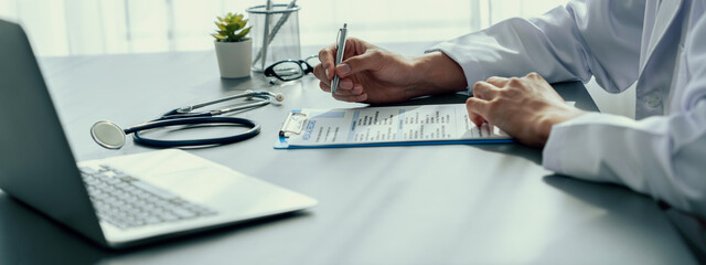 Doctor carefully review detailed medical report with laptop and diagnosing illness for effective...