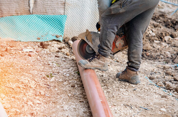 Laying plastic drainage pipes into the ground as part of new drainage system on residential project