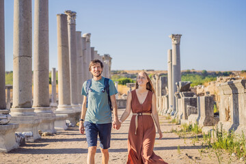 Loving couple of tourists at the ruins of ancient city of Perge near Antalya Turkey. Traveling with...