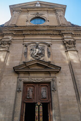 Facade and entrance of the Basilica di Santa Trinita with colorful stained glass in the background, Florence ITALY