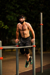 A young man with a beard ,doing sports on a street,sports ground
