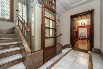 Residential apartment building with vintage elevator and access to housing with hall full of...