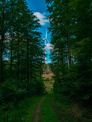 A wind turbine stands in the forest on a mountain in Germany
