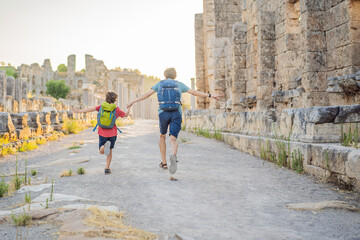 Fototapeta na wymiar dad and son tourists at the ruins of ancient city of Perge near Antalya Turkey. Traveling with kids concept