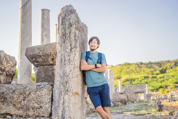 Tourist man at the ruins of ancient city of Perge near Antalya Turkey
