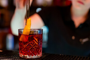 woman hand bartender making negroni cocktail in bar