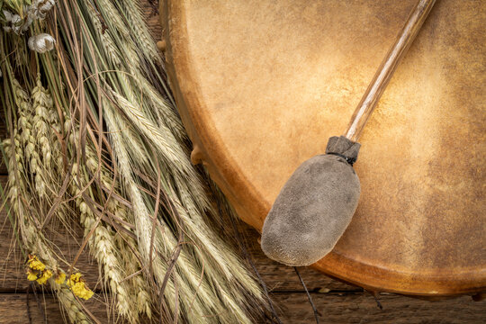 handmade, native American style, shaman frame drum with a beater and bouquet of dried wildflowers and grain stalks