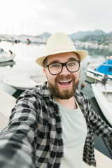 Traveller millennial man taking selfie of luxury yachts marine during sunny day - travel and...