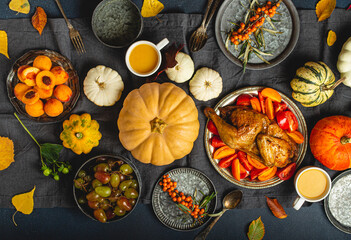 Thanksgiving festive table composition with roasted turkey, pumpkins, vegetable salad, fruit,...