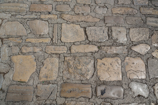Elaborately laid cobblestones or virgin stone pavement for walkway, street or square, garden design and landscaping, road building, background, texture, close up