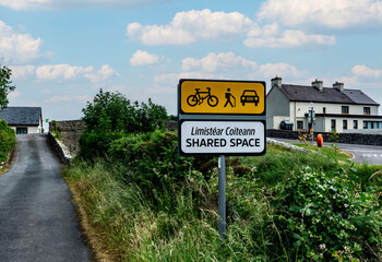 Obraz premium A sign along the Royal Canal, in Cloondara, County Longford indicating the the narrow roadway is a shared space for cars, cyclists and pedestrians.