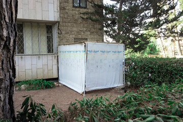 A white Sukkah in the yard of a nice building in Jerusalem - Israel. before the Sukkot jewish holiday 
