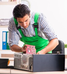 Young engineer repairing broken computer at the office