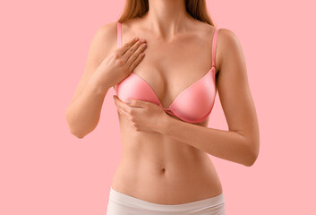 Young woman in bra on pink background