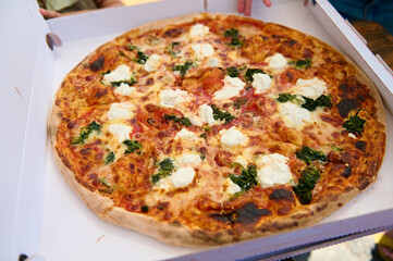 Neapolitan homemade pizza margarita from the brick oven in a disposable cardboard box. Traditional Pizza Margherita