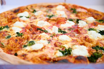 Extreme closeup of traditional Italian pizza Margherita, garnished with fresh basil leaves. Italian cuisine and culture. Food