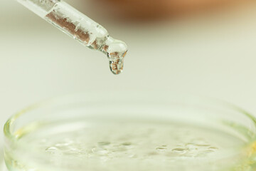 Oil drop with glass chemical container background, laboratory tests, drug creation, bubbles, pipette