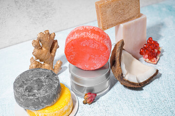 Different handmade solid shampoo, fruits and cream on light background, closeup