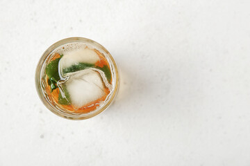 Glass of ice tea with mint on white background