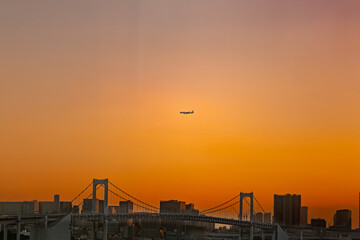 都市風景　夕焼けのレインボーブリッジと飛行機
