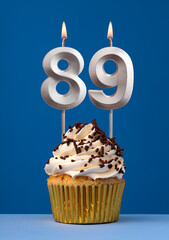 Vertical birthday card with cake - Lit candle number 89 on blue background