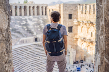 Man tourist explores Aspendos Ancient City. Aspendos acropolis city ruins, cisterns, aqueducts and...