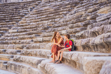 mother and son tourists explores Aspendos Ancient City. Traveling with kids concept. Aspendos...