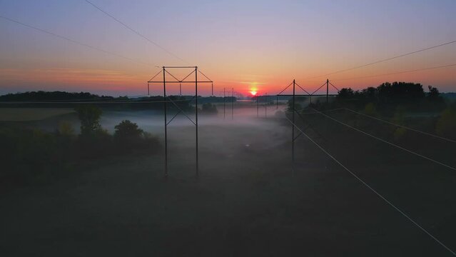 Amazing arial view of Autumn foggy landscape with power grid utility poles.
