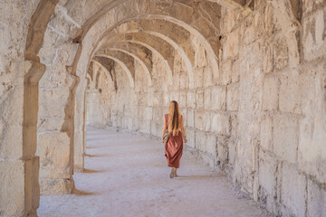 Woman tourist explores Aspendos Ancient City. Aspendos acropolis city ruins, cisterns, aqueducts...