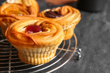 Grid of tasty cruffins with jam on black background