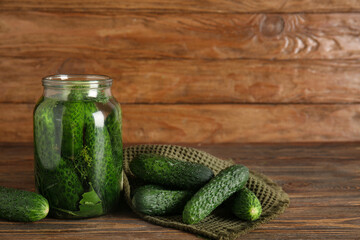 Jar with fresh cucumbers for canning on wooden background
