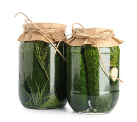 Jars with canned cucumbers on white background