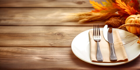 Thanksgiving autumn place setting with cutlery and arrangement of fall leaves. Autumn place setting with fall leaves, napkin and pumpkins. 	