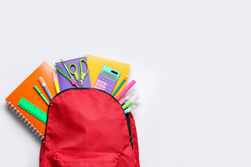 Composition with red school backpack and different stationery on white background