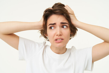 Close up of girl in panic, looking around, holding hands on head, facing trouble, complicated...