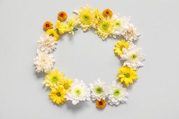 Frame made of beautiful chrysanthemum flowers on grey background